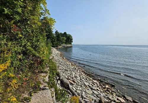 The shoreline at Shorewood Promenade prior to any construction, showing the existing conditions of the site - a narrow rocky beach.