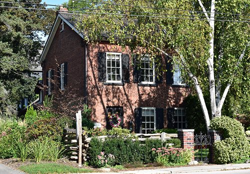 293 MacDonald Road is a Georgian style brick house has a simple yet elegant design with Flemish bond brickwork and multiple wooden windows dressed with shutters.