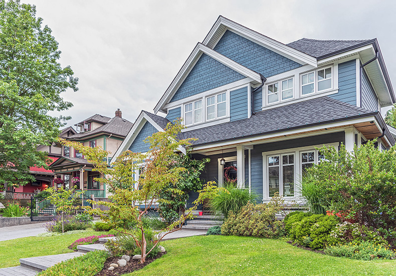 Two story detached house with blue siding characteristic of south Oakville residential neighbourhoods.